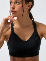 Top deportivo negro de soporte alto con tirantes ajustables, escote en V y tecnología Aloe Vera para mayor suavidad.