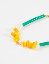 Pulsera elástica con cuentas de piedra natural irregulares en colores verde, amarillo y blanco.
