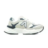 Championes deportivos de diseño robusto, combinando tonos beige, blanco y azul marino. Presentan una estructura multicapa con paneles de malla y refuerzos en gamuza sintética, destacando un logo lateral en forma de A. Cuentan con una suela gruesa y esculpida que proporciona amortiguación y soporte.