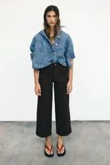 Jeans de tiro alto con diseño wide leg y corte cropped. Presenta cinco bolsillos, cierre frontal con cremallera y botón metálico.