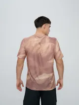 Remera deportiva Umbro modelo Niso, de manga corta y cuello redondo, con estampado abstracto en tonos negro y gris, y logo de la marca impreso en el pecho.