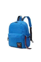 Mochila Las Oreiro color azul, con diseño acolchado y un bolsillo frontal con cierre. Incluye un bolsillo lateral de red con cordón ajustable para botellas y un llavero decorativo de cordones rojos y grises. El logo de la marca está en un parche negro en la parte inferior delantera.