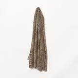 Pashmina rectangular con estampado de cebra en tonos beige y negro, con bordes desflecados.