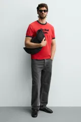 Bolso de hombro tipo hobo de nylon negro, con diseño curvo y asa ajustable. Cuenta con compartimento principal con cierre de cremallera y bolsillo interior con cremallera.