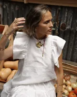 Collar con dije grande de bronce con forma orgánica y textura rugosa, suspendido de un cordón negro. Incluye cordones intercambiables.