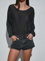 Short de jean blanco con tachas doradas decorativas en los bolsillos delanteros y en los laterales, talle medio y cierre frontal con botón y cremallera.