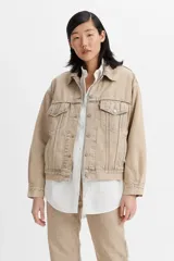 Campera de jean estilo trucker, color beige, con cierre frontal de botones metálicos, bolsillos con solapa en el pecho y costuras reforzadas.