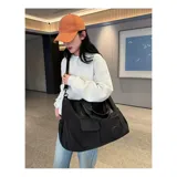 Bolso deportivo multifunción color negro, con diseño liso, compartimento principal con cierre, bolsillo frontal con solapa y bolsillo frontal con cierre. Cuenta con doble asa de mano y correa de hombro ajustable y extraíble. Incluye detalle de logo circular en la parte inferior.