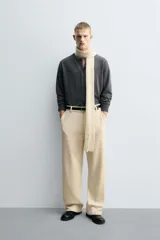 Pantalón de corte wide fit confeccionado en pana de algodón color marrón oscuro. Presenta bolsillos frontales, bolsillos traseros de vivo con botón y cierre frontal con cremallera y botón.