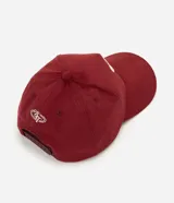 Gorra masculina de color bordó, confeccionada en tejido texturizado tipo gamuza, con visera curva, regulador y bordado frontal en lettering blanco.