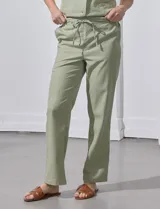 Pantalón de corte recto confeccionado en mezcla de lino, color verde claro. Presenta una pretina ancha con lazo de ajuste frontal y bolsillos laterales verticales.