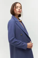 Tapado de paño azul con diseño de doble botonadura, solapas amplias y corte recto. Cuenta con bolsillos laterales discretos y forro interior.