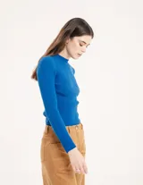 Polera negra de tejido de punto acanalado, con cuello alto y mangas largas.