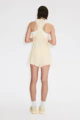Musculosa deportiva de color beige, confeccionada en tejido funcional con tecnología DryMove para absorber el sudor. Presenta un diseño de corte estándar, cuello redondo y aberturas laterales en el bajo.