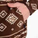 Buzo polar marrón con estampado geométrico en tonos beige y blanco, cuello alto con cierre de botones a presión, bolsillo tipo canguro y bolsillo en el pecho con cierre. Marca Merrell.