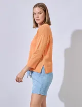 Buzo color salmón en tejido calado, marca Cable & Gauge. Cuello a la base, largo de manga 3/4. Ruedo y puño en tejido acanalado.