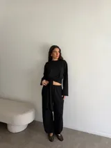 Conjunto de dos piezas de viscosa y poliéster color gris melange, compuesto por un buzo de manga larga y un pantalón largo de corte recto con lazo ajustable en la cintura.