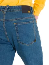 Jeans de mezclilla azul con calce slim, diseño clásico de cinco bolsillos y costuras en contraste.