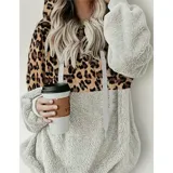 Buzo tipo canguro de polar, con diseño combinado en animal print de leopardo en la parte superior y color gris claro en la parte inferior. Cuenta con capucha, cordones ajustables y cierre frontal.
