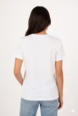 Remera de manga corta color beige, con cuello redondo y diseño al cuerpo. Presenta un estampado frontal multicolor de estilo veraniego con temática marina y detalles con glitter.