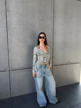 Top de manga larga con estampado abstracto en tonos celestes y marrones, escote en V y diseño cruzado.