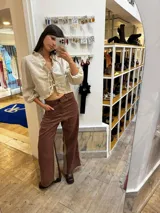 Pantalon sastrero de lino color marrón con paneles laterales en contraste beige, diseño de tiro alto y corte recto. Presenta un bordado de caballo en el bolsillo frontal.