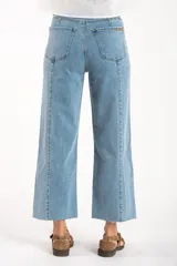 Jean de corte recto y tiro medio, confeccionado en denim de algodón con un toque de elastano. Presenta costuras verticales decorativas a lo largo de las piernas y un ruedo deshilachado.