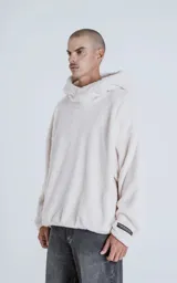 Hoodie oversize de piel sintética tipo corderito, color off-white, con capucha ajustable y bolsillo canguro frontal.