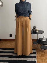 Pantalón de tiro alto con corte wide leg y diseño de pinzas frontales. Confeccionado en lino natural, presenta una silueta amplia y fluida con bolsillos laterales.