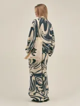 Conjunto de camisa y pantalón de lino color verde con estampado de flores blancas. La camisa es de manga larga y corte holgado.