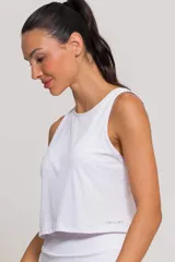 Musculosa deportiva color blanco, sin mangas, de cuello redondo y corte corto, confeccionada en microfibra de poliamida con tecnología de secado rápido y protección UV.