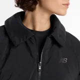 Campera bomber New Balance de corte holgado y diseño minimalista. Presenta cuello camisero, cierre frontal completo, mangas raglán con puños elásticos y cintura elástica. Incluye bolsillos laterales y el logo de la marca bordado en el pecho.