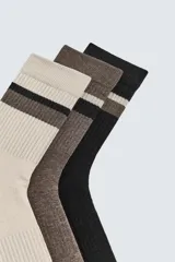 Pack de tres pares de calcetines de tejido acanalado, con bandas horizontales en el borde superior. Incluye un par beige, uno marrón y uno negro.