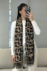 Bufanda rectangular con estampado animal print de leopardo en tonos marrones y negros, con terminación de flecos en los extremos.