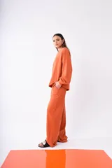Pantalón ancho color naranja de tejido de punto con bolsillos laterales.