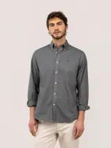 Camisa de hombre de corte regular fit, color gris oscuro, confeccionada en algodón con acabado vintage de tintado en prenda. Cuenta con cuello button-down, cierre frontal de botones, manga larga y logo bordado en el pecho.