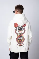Buzo tipo canguro de corte oversize, color blanco, con capucha y cordones ajustables. Presenta un pequeño estampado de una rosa roja en el pecho y un bolsillo frontal tipo canguro.