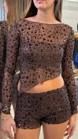 Short de tiro bajo confeccionado en tela transparente con lentejuelas oscuras aplicadas en diseño floral. Presenta un corte ajustado y acabado brillante.