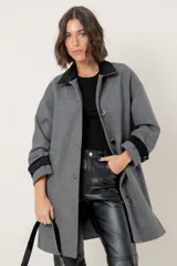 Tapado de corte recto con estampado de pata de gallo en tonos azul y gris. Presenta cuello camisero y detalles en los puños en color negro, cierre frontal con botones y bolsillos laterales.