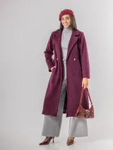 Tapado de paño sofisticado con solapas clásicas, cierre frontal de botones y bolsillos laterales. Presenta un diseño de corte recto y estructura elegante.