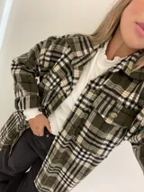 Remera de morley color mostaza, de manga larga, con cuello alto fruncido y terminaciones fruncidas en las mangas.