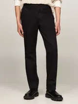 Pantalón chino negro de Tommy Hilfiger, modelo Denton, con pierna recta y confeccionado en satén de algodón elástico. Cuenta con cierre de cremallera con botón, dos bolsillos ribeteados en la cintura y dos bolsillos traseros de ojal con botón. Logo de Tommy Hilfiger bordado en la parte trasera.