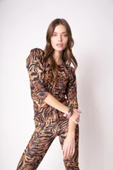 Remera de lycra color marrón con estampado animal print de cebra en negro, corte ajustado y mangas 3/4 con frunce en los hombros.