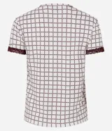 Blusa de pijama de cuello redondo y manga corta, confeccionada en tejido peach touch color blanco con estampado geométrico de corazones en tono bordó. Cuenta con detalles de encaje en los puños y un pequeño moño decorativo en el escote.