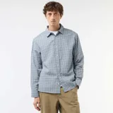 Camisa de manga larga con diseño de cuadros en tonos azules y blancos, cuello camisero y cierre frontal de botones.