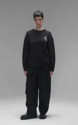 Sweater de cuello redondo color negro, con diseño de calavera bordado en relieve en color blanco en la espalda. Presenta terminaciones en punto rib en cuello, puños y ruedo, con un calce relajado y oversize.
