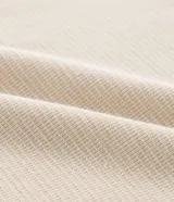 Remera de corte regular confeccionada en tejido texturizado de algodón y poliéster. Presenta cuello redondo y bordes de mangas con detalle de rayas contrastantes en blanco y gris.