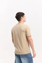 Remera de algodón color beige, de manga corta y cuello redondo, con logo estampado en el pecho en tono morado.