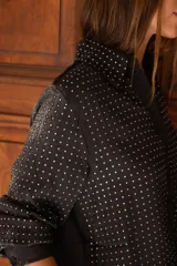 Conjunto de dos piezas compuesto por camisa de manga larga con botones frontales y pantalón de corte recto, ambos en color negro con estampado de pequeños puntos brillantes tipo strass.