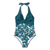 Malla entera de color verde oscuro, combinada con un diseño floreado en la parte inferior. Presenta escote halter cruzado y fruncidos en la zona del abdomen.